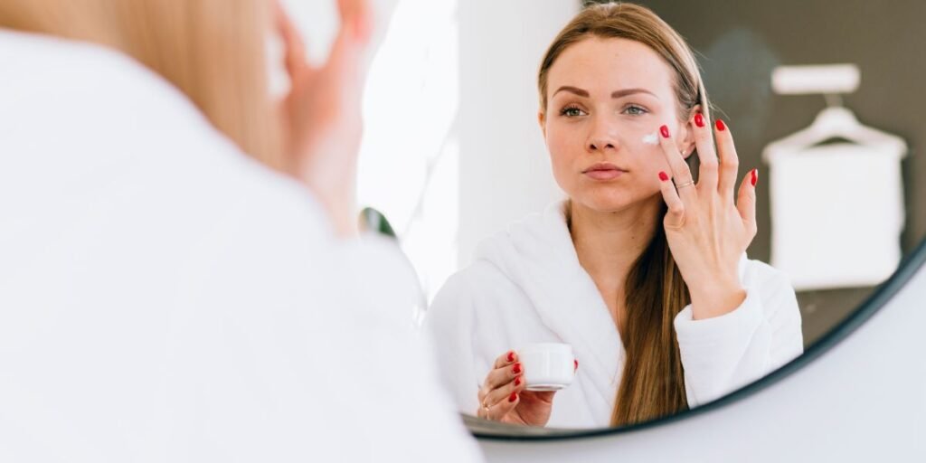 Women sit in front of mirrior and apply best retinol cream